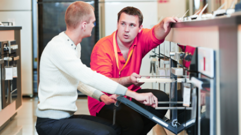 verkoper toont inbouwoven aan klant