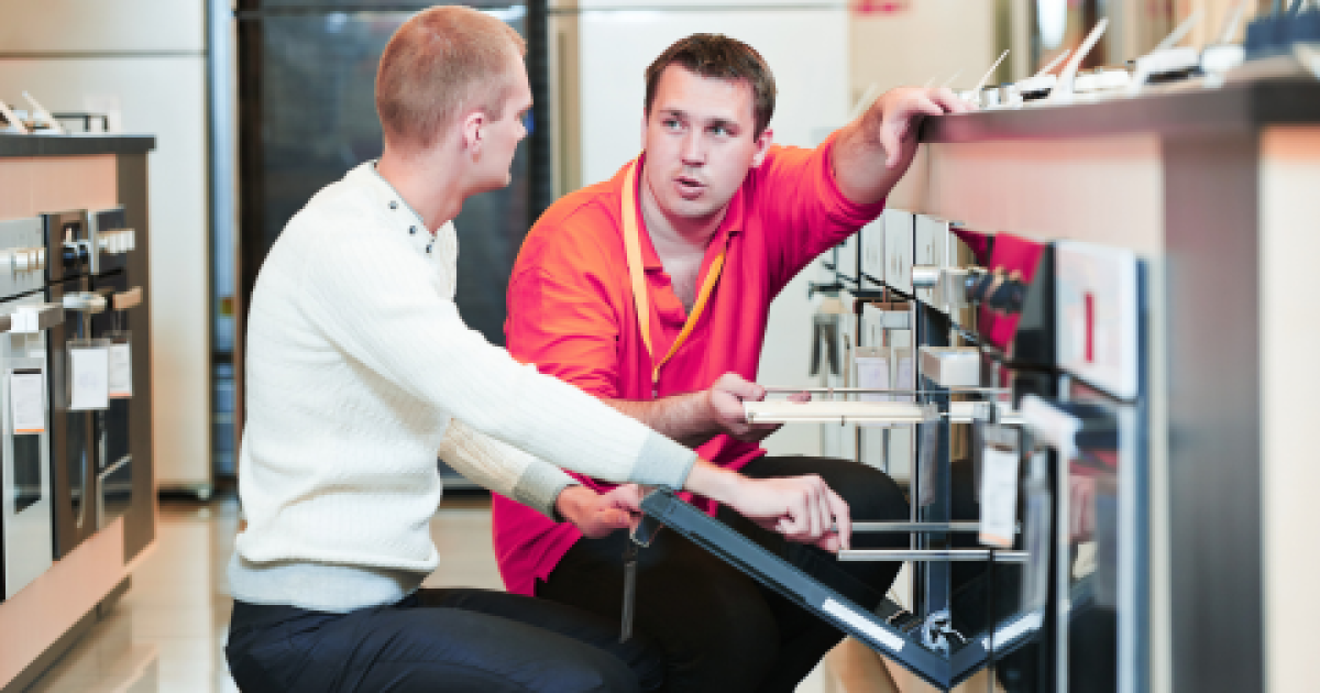 verkoper toont inbouwoven aan klant